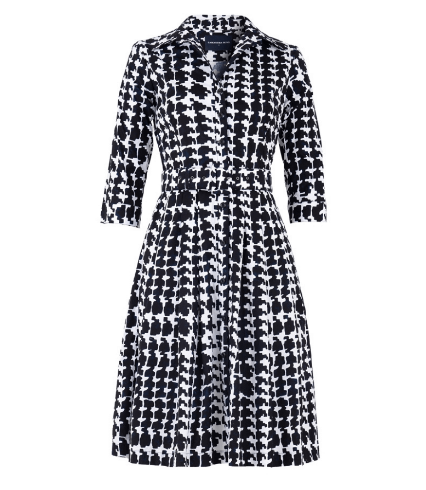 A knee-length dress with a collared neckline, three-quarter sleeves, and a flared skirt. Features a bold allover abstract pattern and fitted waist.