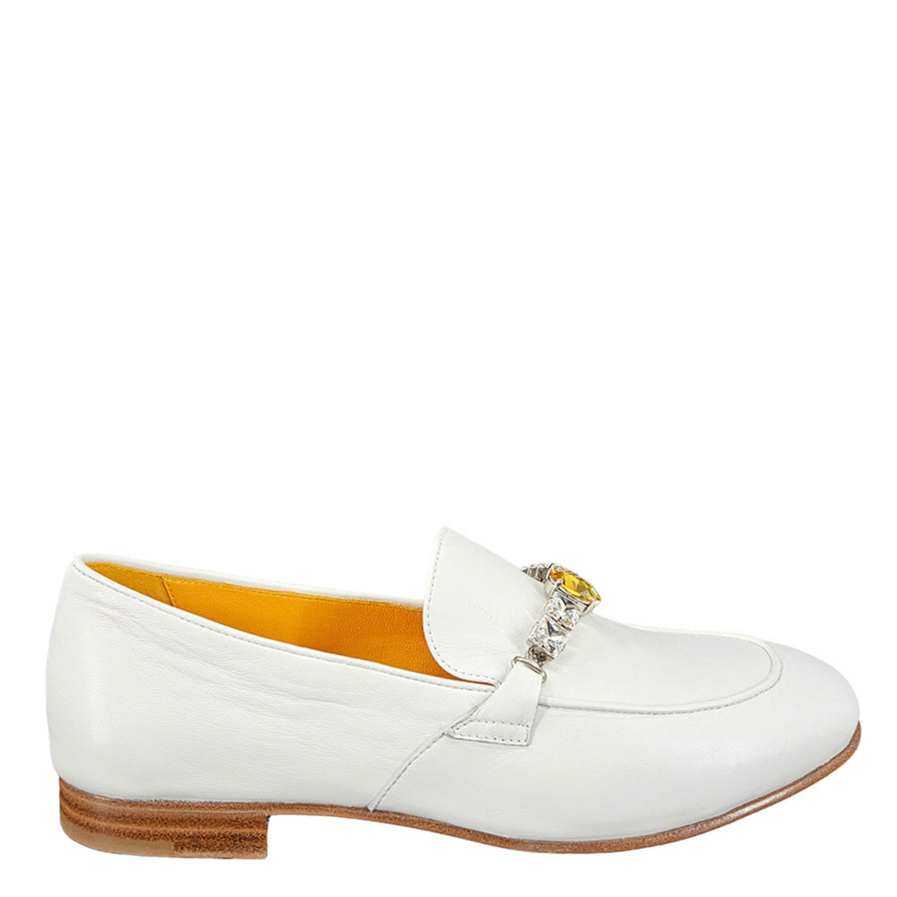 White loafer shoe with a decorative brooch on a white background