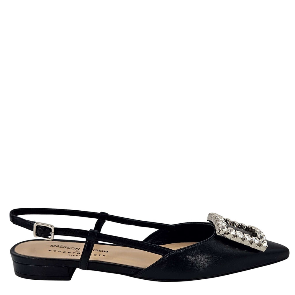 Black Italian leather slingback flat by Madison Maison with a pointed toe, low heel, and large rectangular crystal-embellished buckle on the front. Handcrafted in Italy with adjustable slim strap.