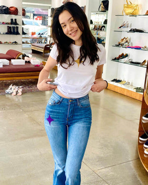 Flared-leg pants made in Italy with a mid-rise fit, featuring front and back pockets and star-shaped accents on the hip, lower leg, and back pocket. Displayed from multiple angles against a clean background