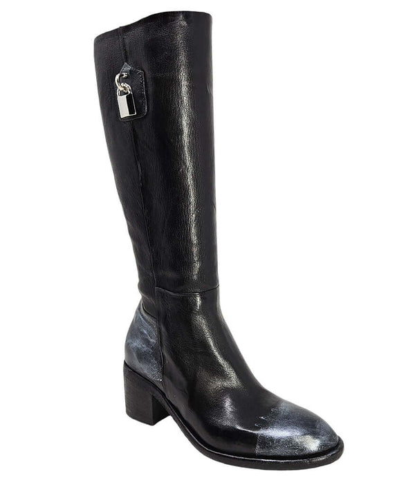 Tall leather boot featuring a softly rounded toe, mid-height stacked block heel, full side zipper for easy on and off, and a decorative metal lock accent near the top shaft. Crafted from premium leather with artisanal distressed detailing at the toe and h