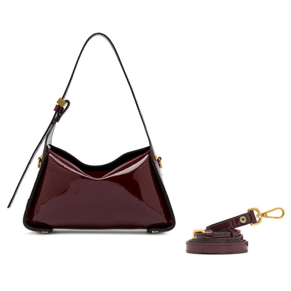 Shiny burgundy handbag with a detachable strap on a white background