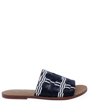 Handmade Italian slide sandal featuring a wide woven upper with interlaced detailing and a flat leather sole. Shown from side and front angles against a clean background.