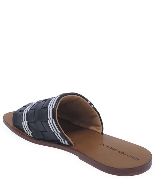 Handmade Italian slide sandal featuring a wide woven upper with interlaced detailing and a flat leather sole. Shown from side and front angles against a clean background.