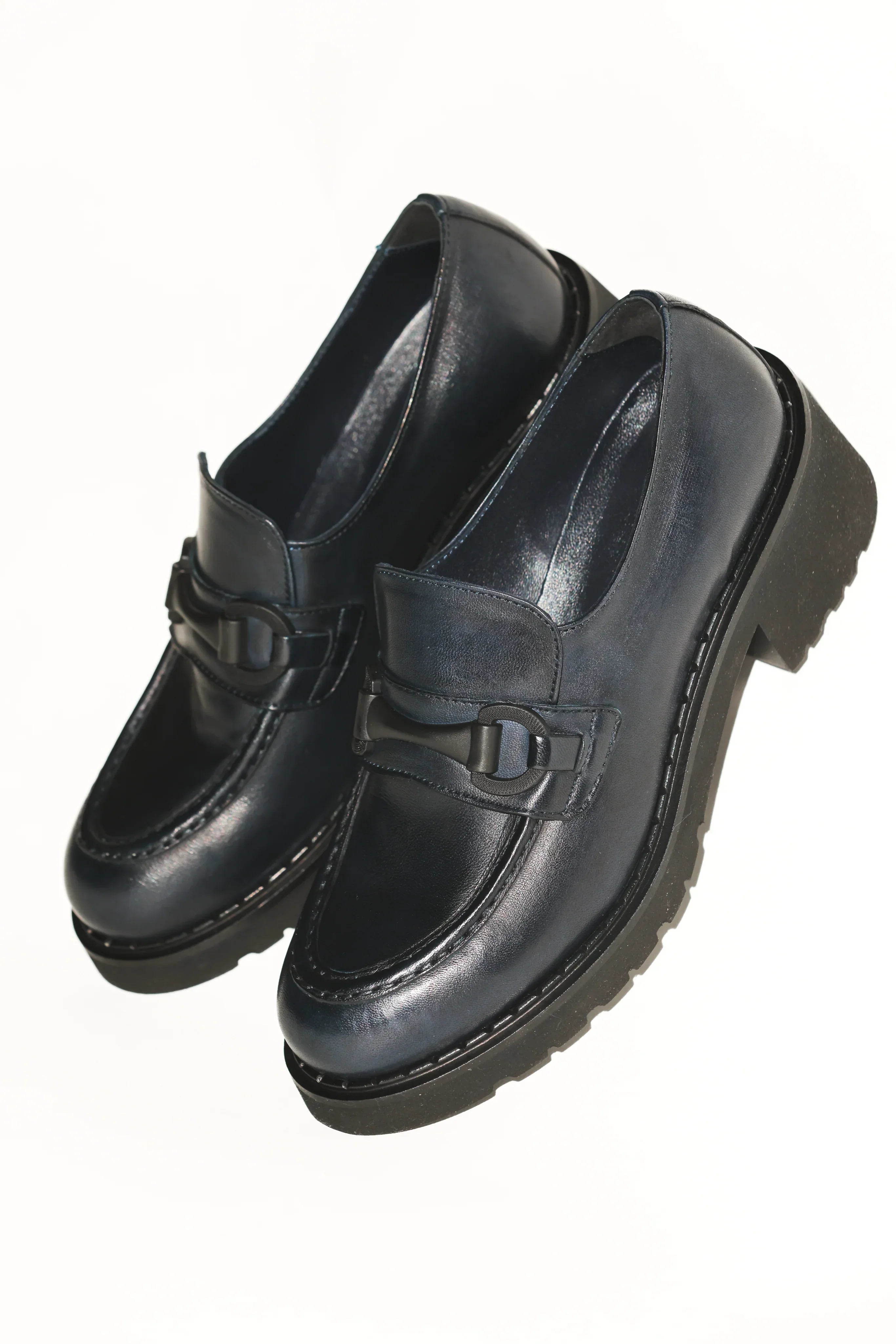 A pair of navy leather loafers with a lug sole.