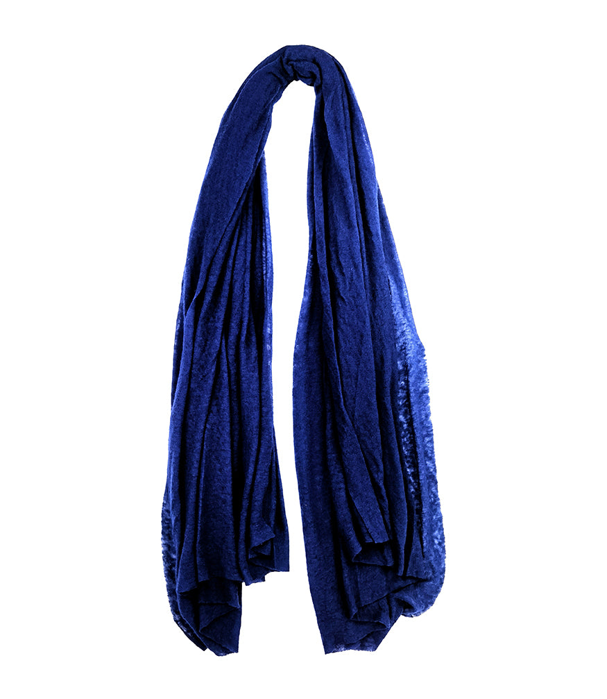 A lightweight, rectangular scarf with soft texture and raw edges, draped to show length and fluidity