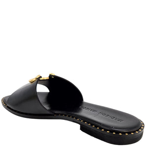 Black sandal with gold accents on a white background