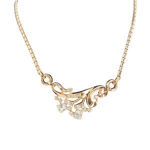 Gold necklace with floral design and small diamonds on a white background