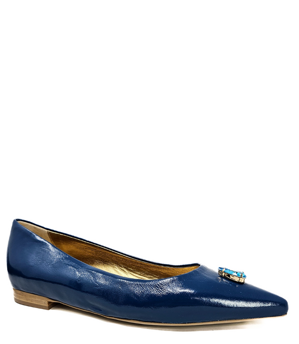 Pointed-toe slingback flat featuring a low block heel, textured fabric upper, slim ankle strap with side buckle, and a large jeweled buckle embellishment on the toe