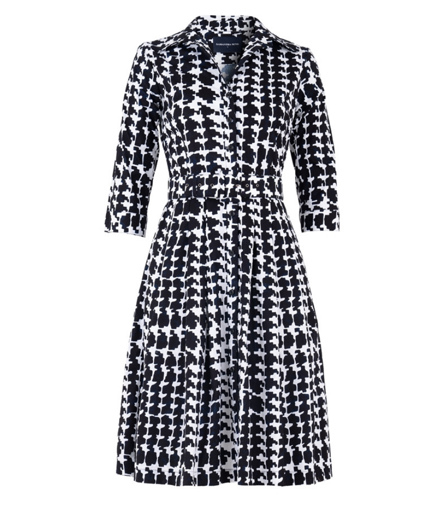 A knee-length dress with a collared neckline, three-quarter sleeves, and a flared skirt. Features a bold allover abstract pattern and fitted waist.