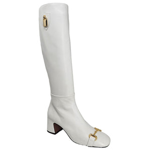White knee-high boot with gold zipper and decorative buckle on a white background