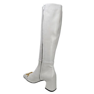 White knee-high boot with a gold zipper on a white background