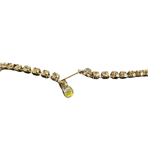 Gold necklace with a central yellow gemstone on a white background