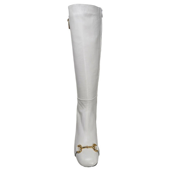 White knee-high boot with gold detail on a white background