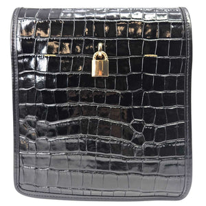 Black crocodile-patterned clutch bag with a gold lock on a white background