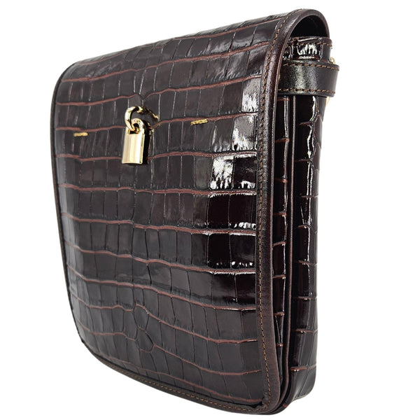 Black crocodile-patterned handbag with a gold lock on a white background