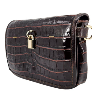 Black crocodile-patterned handbag with a gold lock on a white background