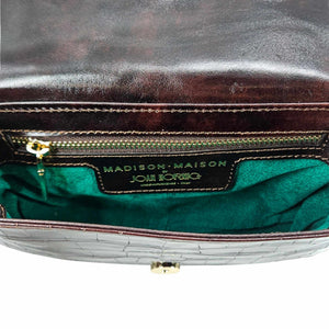 Close-up of a handbag with 'Madison Maison' branding on a white background