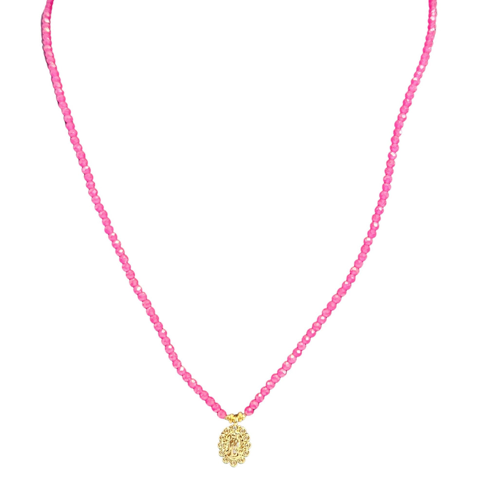 Necklace with pink beads and a gold pendant on a white background