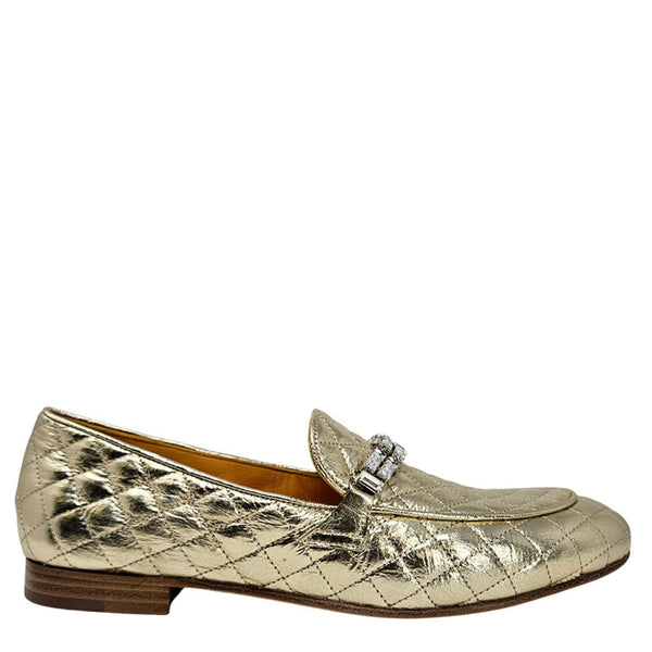 Gold metallic loafers on a white background