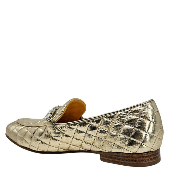 Gold metallic loafers on a white background