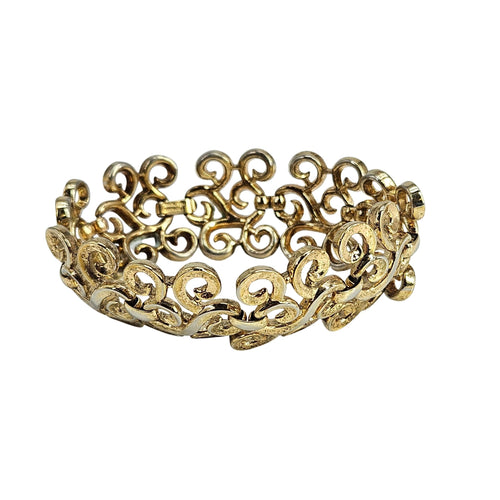 Gold bracelet with intricate design on a white background