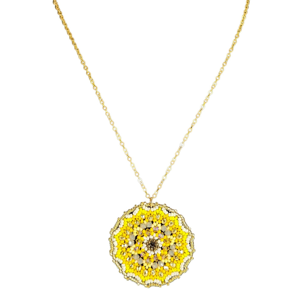 Gold necklace with a yellow and black pendant on a white background
