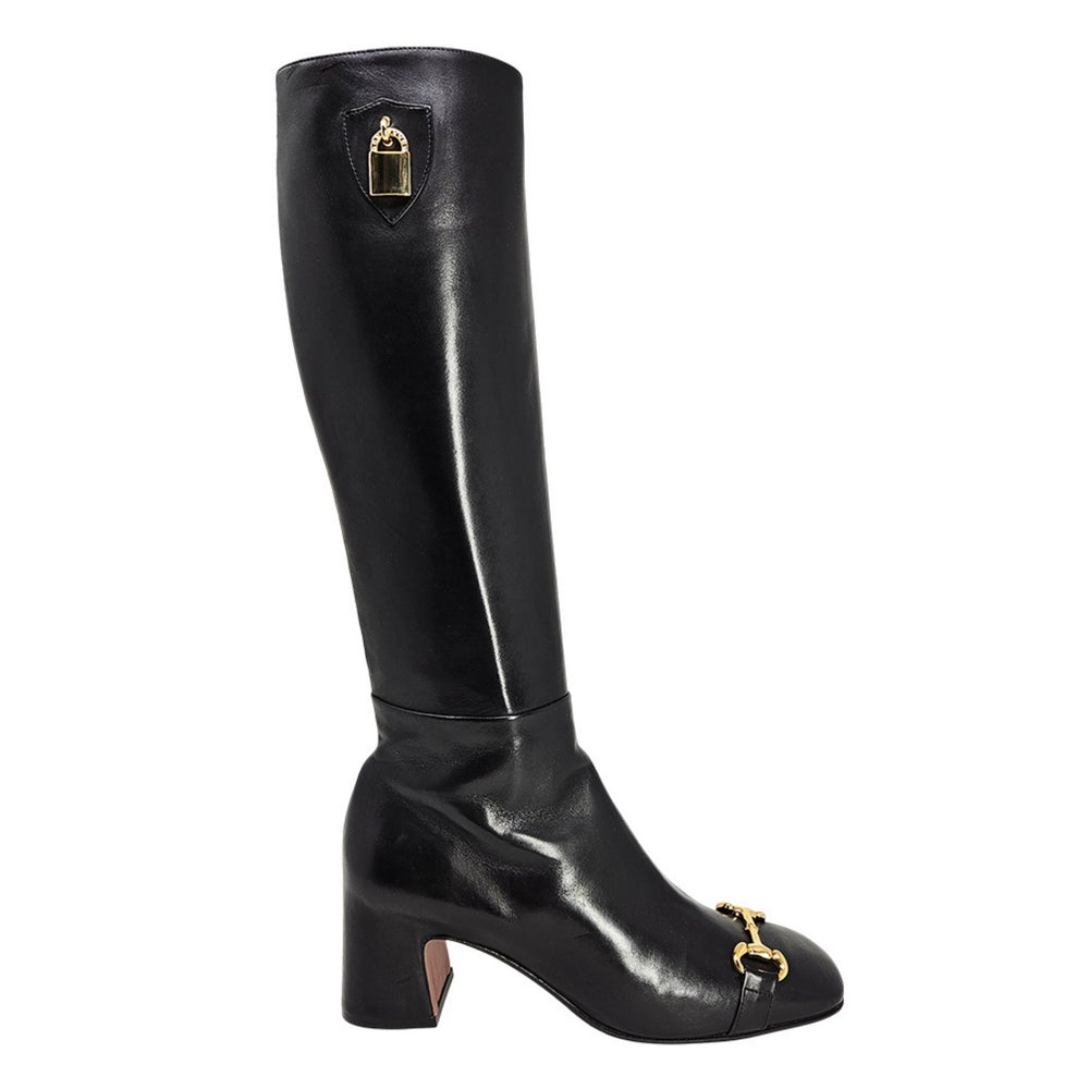 Black knee-high boot with gold accents on a white background