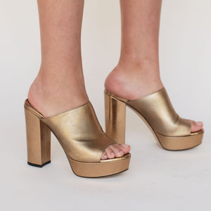 image of womens legs wearing gold platform sandals 