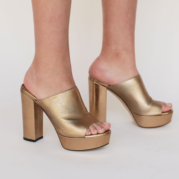 image of womens legs wearing gold platform sandals 