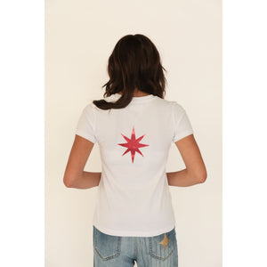 Person wearing a white t-shirt with a red star design on the back, standing against a plain background.