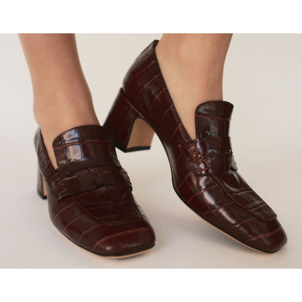 Brown crocodile-patterned shoes on a neutral background