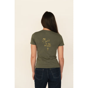 Person wearing an olive green t-shirt with 'Music is the answer' text on the back, standing against a plain background.