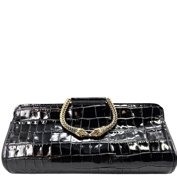 Black crocodile-patterned handbag with a gold handle on a white background