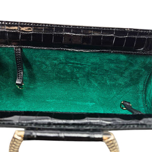 Close-up of a green leather bag with gold accents on a white background