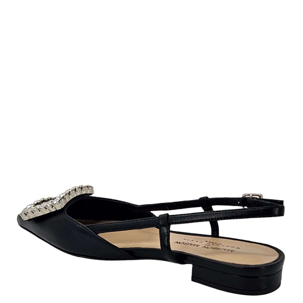 Black Italian leather slingback flat by Madison Maison with a pointed toe, low heel, and large rectangular crystal-embellished buckle on the front. Handcrafted in Italy with adjustable slim strap.