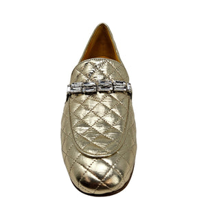Gold quilted loafer with a decorative band on a white background