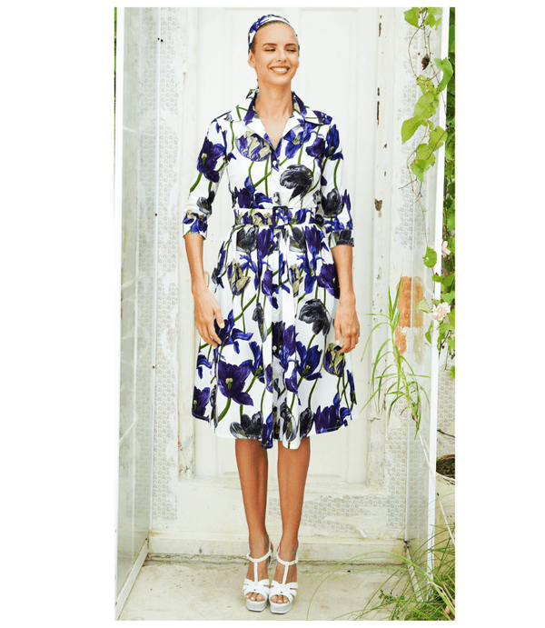 A knee-length dress with a collared neckline, three-quarter sleeves, and a flared skirt. Features a bold allover abstract pattern and fitted waist.