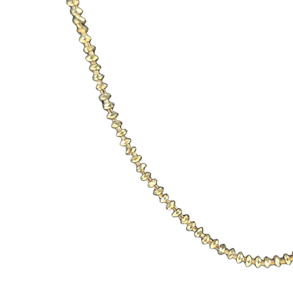 Gold necklace with small beads on a white background