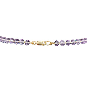 Purple beaded bracelet with gold clasp on a white background