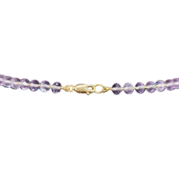Purple beaded bracelet with gold clasp on a white background