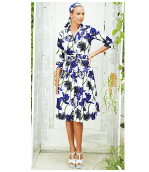 A knee-length dress with a collared neckline, three-quarter sleeves, and a flared skirt. Features a bold allover abstract pattern and fitted waist.