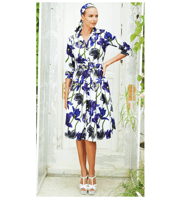 A knee-length dress with a collared neckline, three-quarter sleeves, and a flared skirt. Features a bold allover abstract pattern and fitted waist.