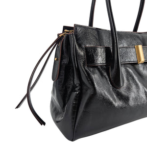 A sleek, black leather handbag with two slender top handles and a horizontal gold bar accent on the front.