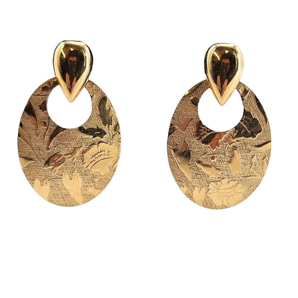 Pair of gold earrings with intricate designs on a white background