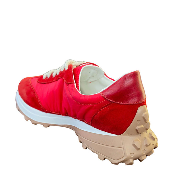 Red sneaker with beige sole on a white background