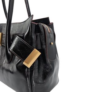 A sleek, black leather handbag with two slender top handles and a horizontal gold bar accent on the front.