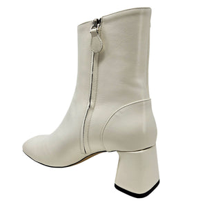 White ankle boot with a block heel on a white background