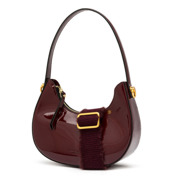 Shiny burgundy handbag with gold accents on a white background