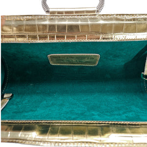 Close-up of a teal handbag with gold accents on a white background